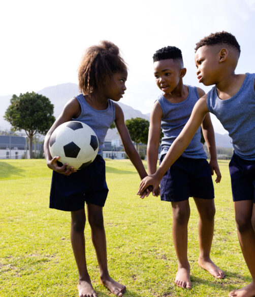 Happy african american schoolchildren playing football on field at school. Elementary school, sports, education and learning concept. Happy african american schoolchildren playing football on field at school. Elementary school, sports, education and learning concept.