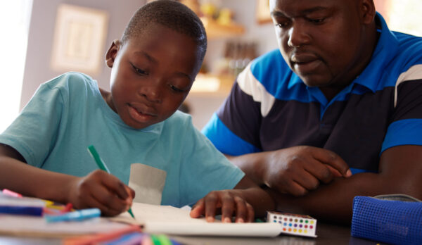 Homeschool, father and kid with color pencils for education, learning and creative development in family home. Dad, child and books for writing, drawing and creativity of art project, homework or fun.