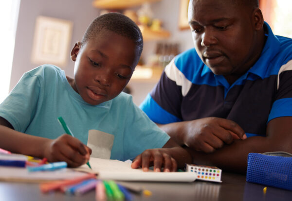 Homeschool, father and kid with color pencils for education, learning and creative development in family home. Dad, child and books for writing, drawing and creativity of art project, homework or fun.