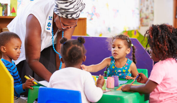 Teacher helping kids in a preschool class