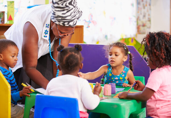Teacher helping kids in a preschool class
